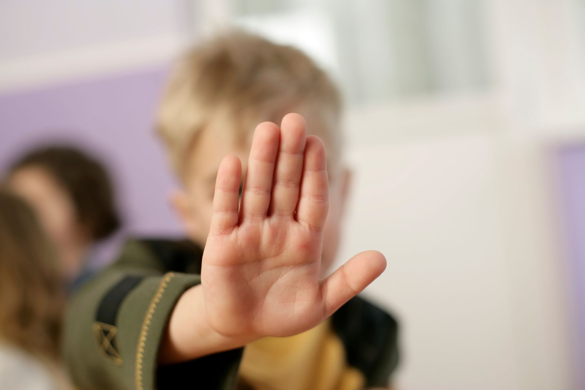 szőke kisfiú az erca elé tartja a kézfejét, stop-ot mutatva